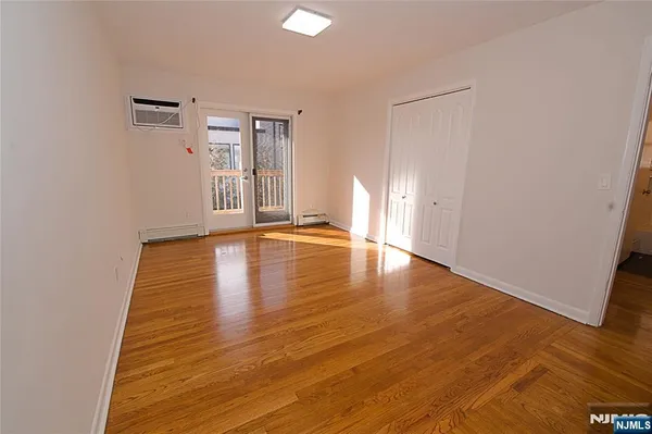 a view of an empty room with wooden floor