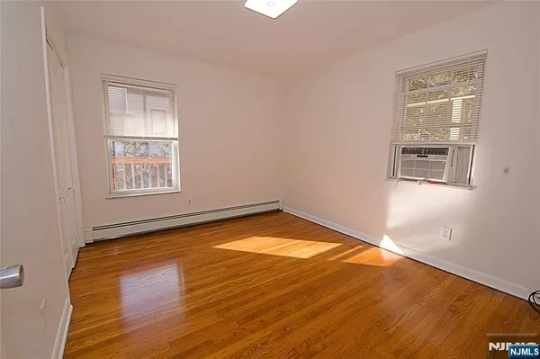 a view of a room with wooden floor and windows