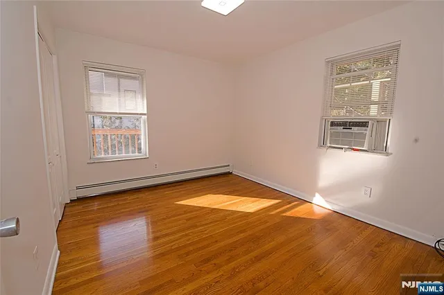 a view of a room with wooden floor and windows
