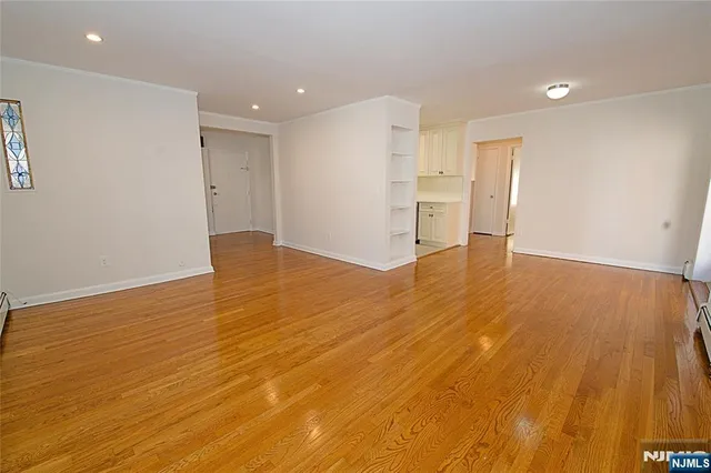 a view of empty room with wooden floor