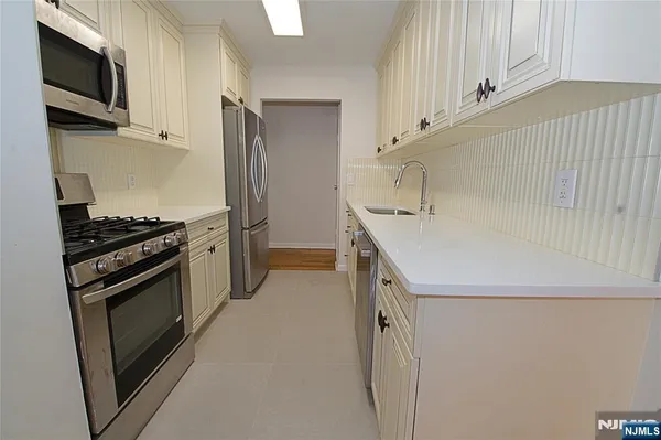 a kitchen with a sink and stainless steel appliances