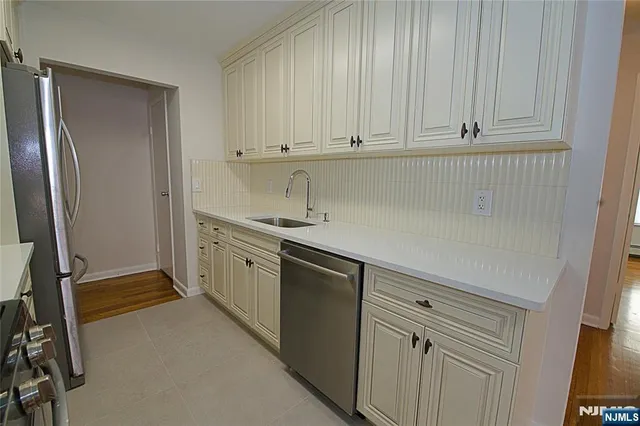 a kitchen with stainless steel appliances white cabinets and a refrigerator