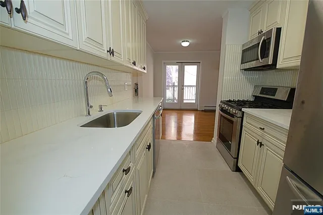 a kitchen with stainless steel appliances granite countertop a sink and a stove top oven
