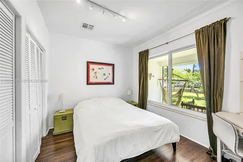 a bedroom with a bed and a large window with outer view