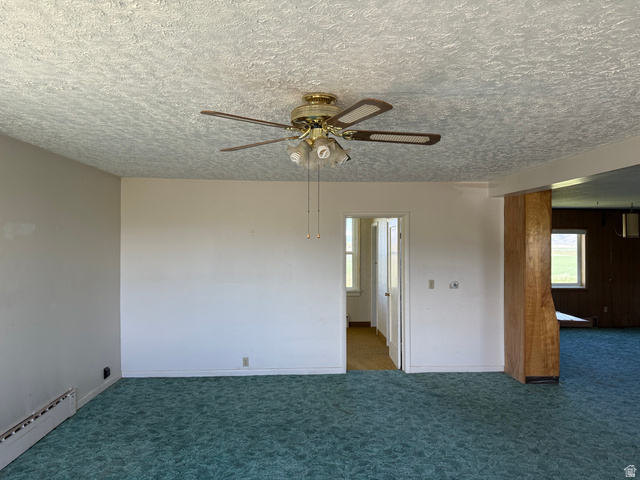 2002 Lund Road Bancroft, ID 83217 - Photo 5 of 28 Interior space featuring a textured ceiling with a brass-finish ceiling fan and light fixture