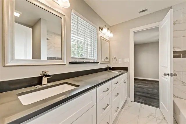 a kitchen with granite countertop white cabinets and sink