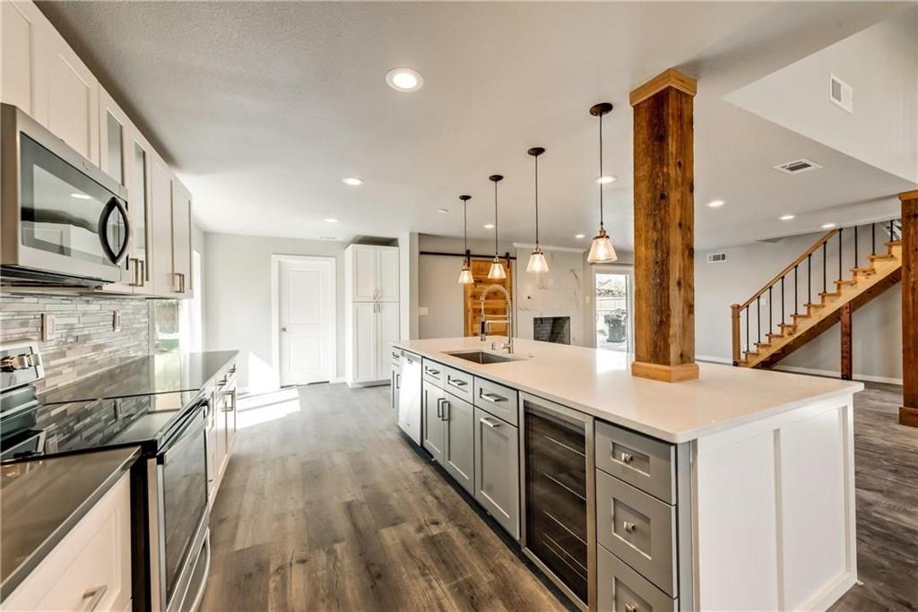 10216 Carry Back Circle Dallas, TX 75229 - Photo 5 of 28 a open kitchen with stainless steel appliances granite countertop a lot of counter space and wooden floors