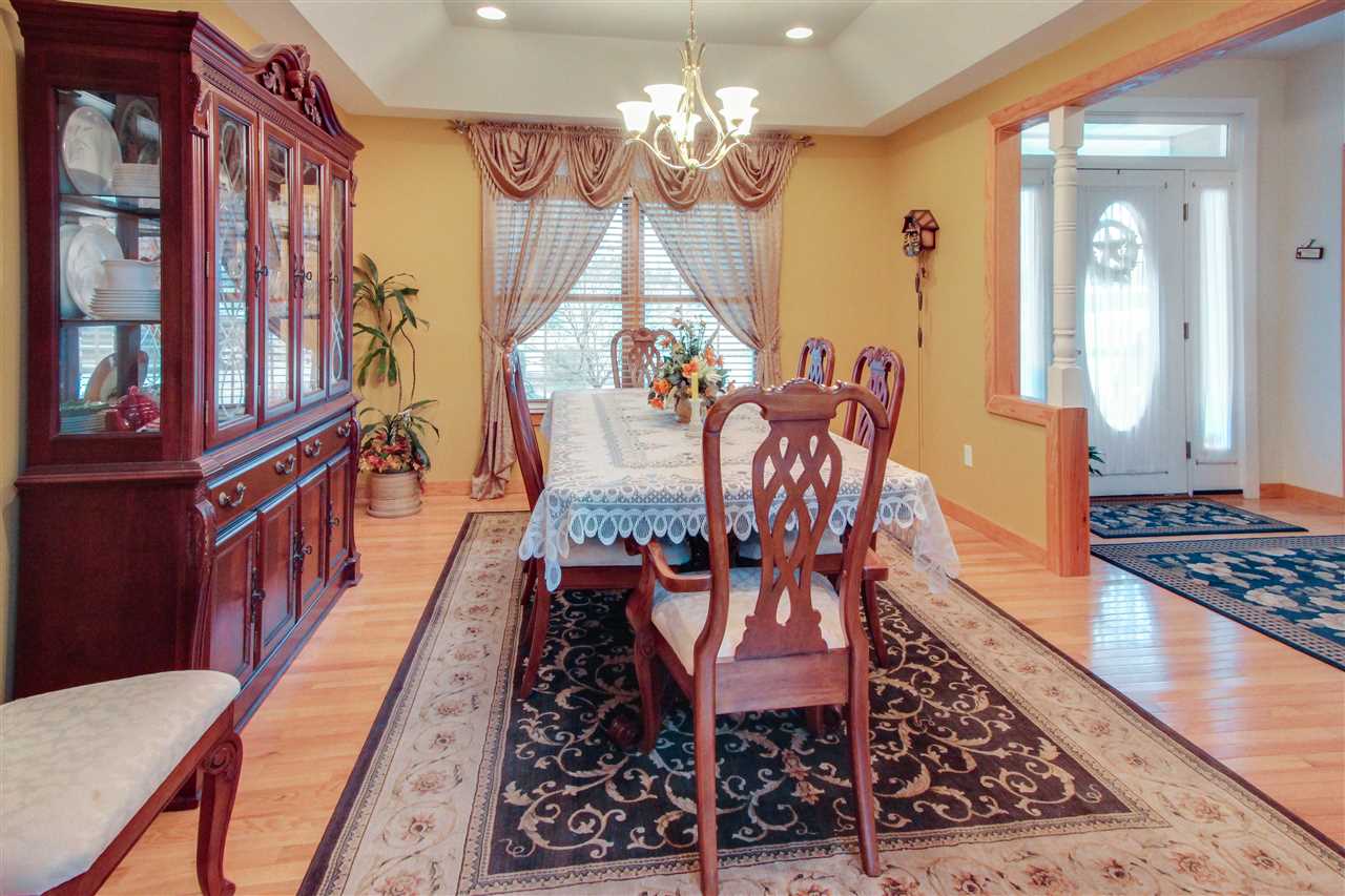 713 Lantz Road Edinburg, VA 22824 - Photo 16 of 27 a dining room with furniture a chandelier and wooden floor