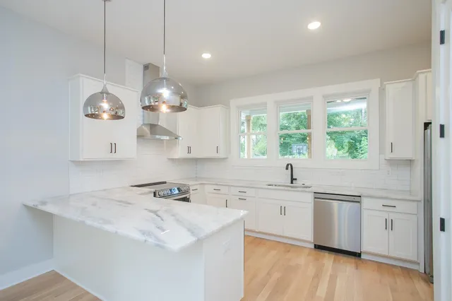 a large kitchen with a large window a refrigerator and a sink