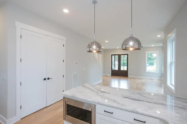 a kitchen with stainless steel appliances granite countertop a sink a refrigerator and window