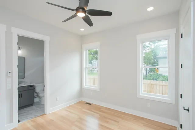 a view of hallway with wooden floor and a ceiling fan
