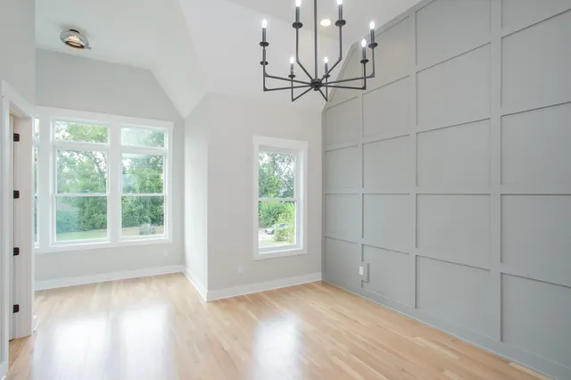 a view of a chandelier in a room with wooden floor windows and chandelier