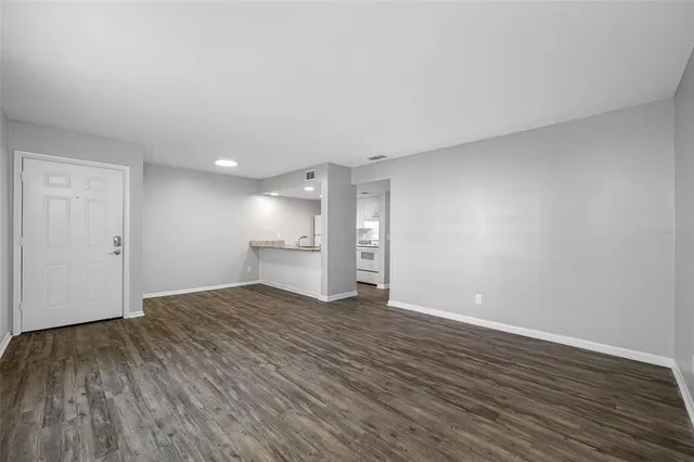 a view of empty room with wooden floor
