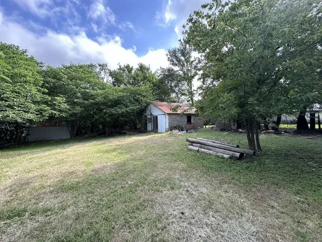 a white house covered with tall trees