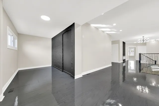 a view of an empty room with wooden floor