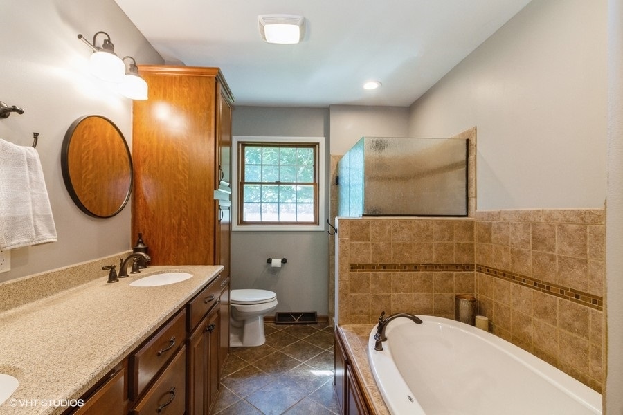 5602 Pagles Road Harvard, IL 60033 - Photo 11 of 23 a bathroom with a granite countertop bathtub sink vanity mirror and toilet