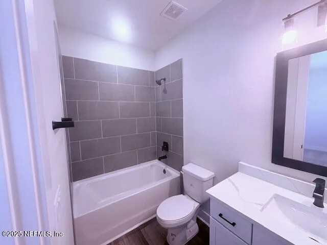 a bathroom with a sink a toilet a mirror a vanity and bathtub
