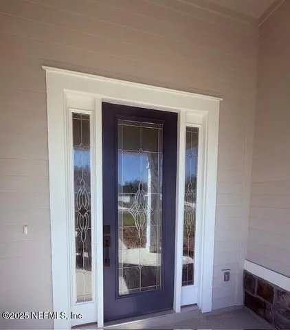 a view of a hallway with wooden floor and a living room