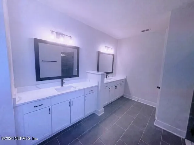 a spacious bathroom with a double vanity sink and a mirror