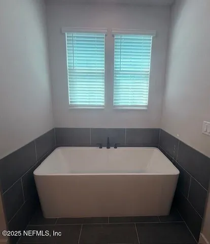 a bath tub sitting in a bathroom next to a window