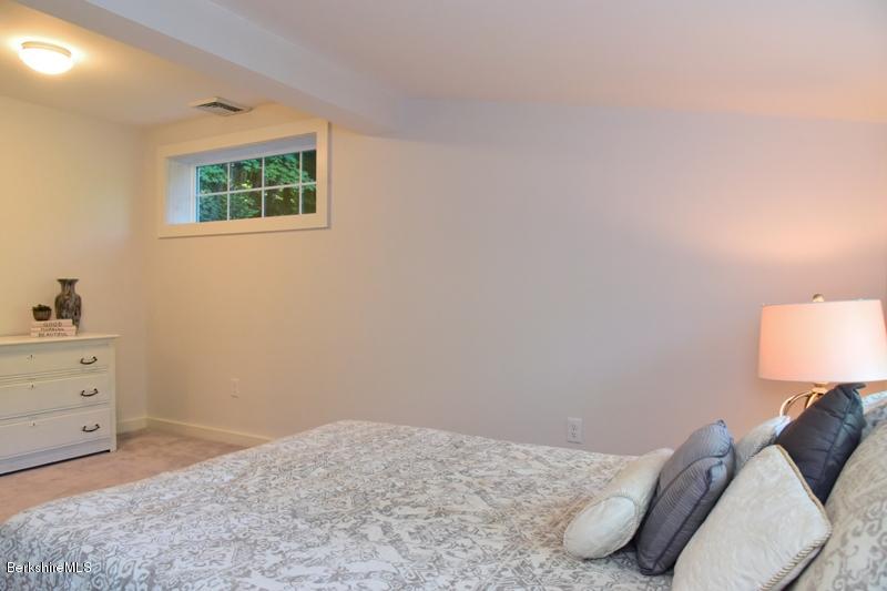 16 Mahkeenac Road Stockbridge, MA 01262 - Photo 23 of 26 a bedroom with a bed and a lamp on dresser