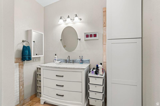 327 North Lodge Road Central, UT 84722 - Photo 19 of 45 Bathroom vanity with a light-colored countertop, an oval mirror, and a three-light fixture