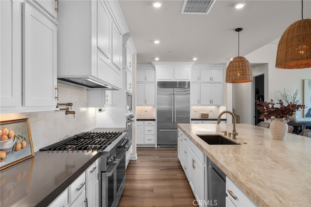 16155 New Canaan Court Riverside, CA 92504 - Photo 9 of 26 a kitchen with refrigerator a stove and a sink