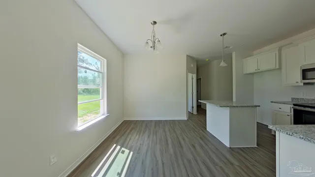 a kitchen with a refrigerator wooden floor and a window
