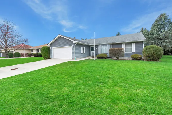 a view of a house with a yard and a large tree