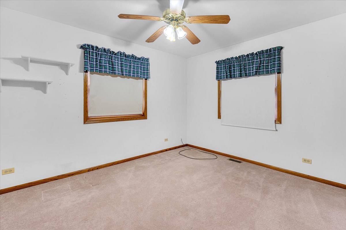 1200 2nd Street Harvard, IL 60033 - Photo 10 of 22 an empty room with wooden floor chandelier fan and windows