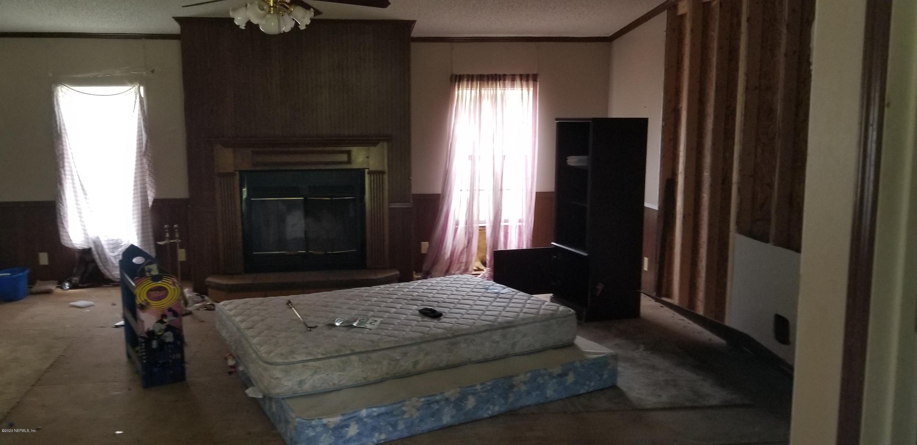 14003 Bradham Road Jacksonville, FL 32226 - Photo 11 of 30 a living room with a bed furniture and a fireplace
