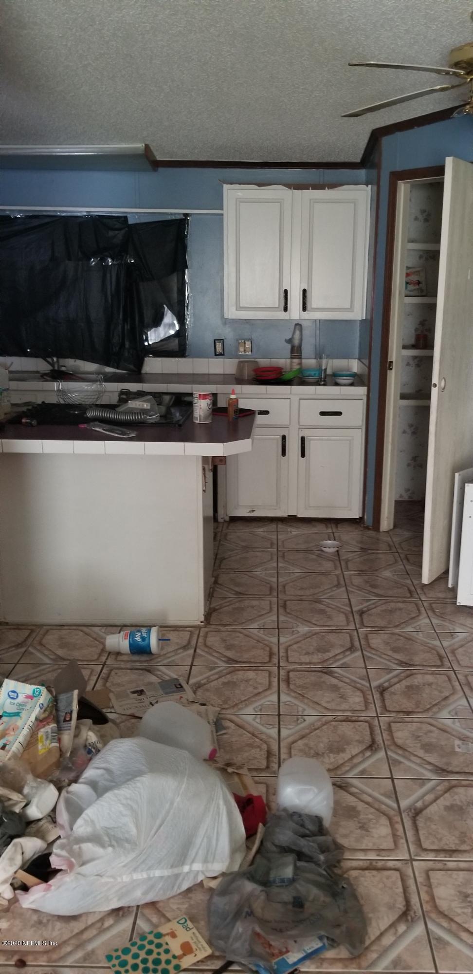 14003 Bradham Road Jacksonville, FL 32226 - Photo 22 of 30 a kitchen with a sink a stove and cabinets