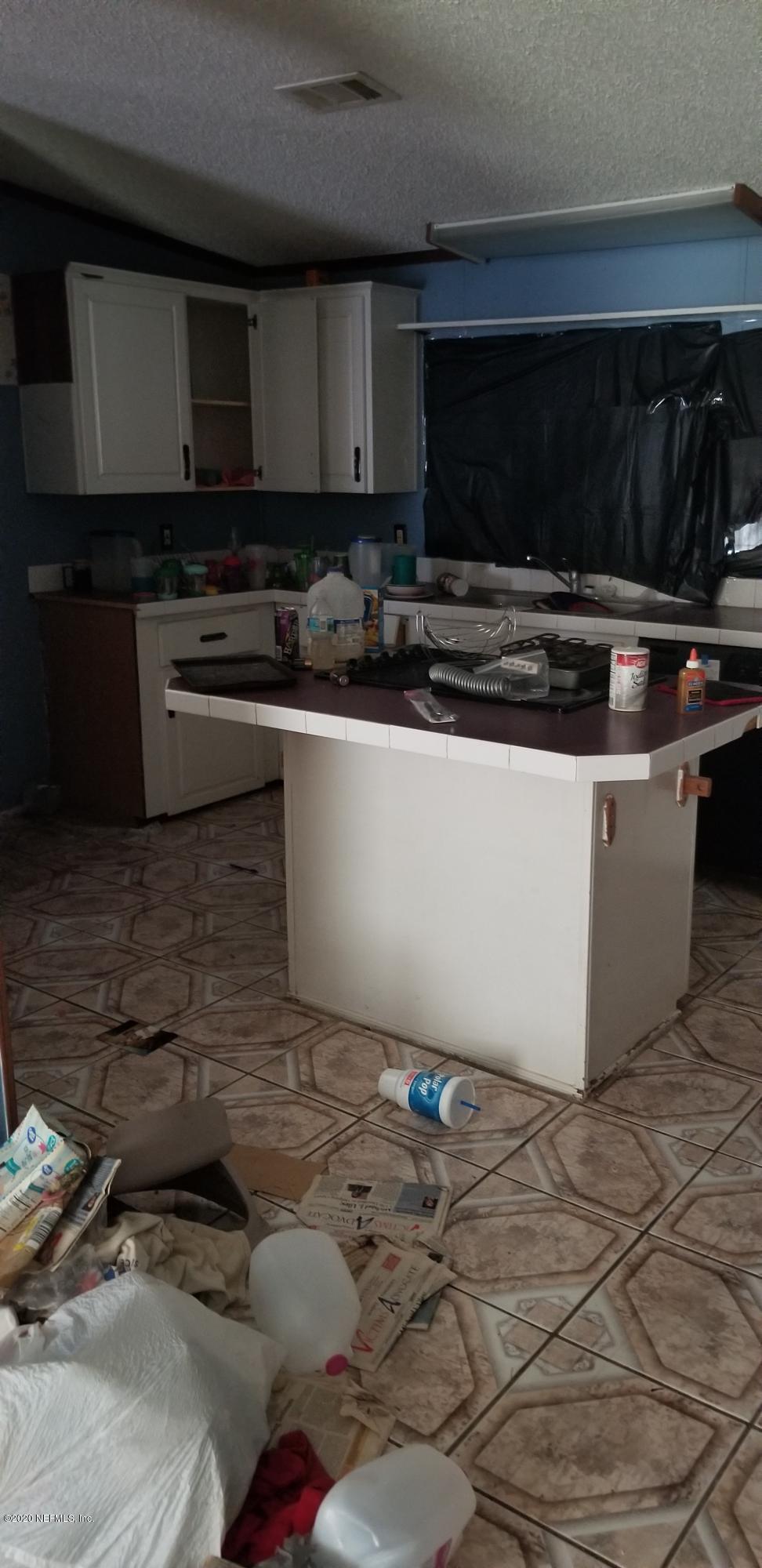 14003 Bradham Road Jacksonville, FL 32226 - Photo 23 of 30 a kitchen with granite countertop a stove and a microwave