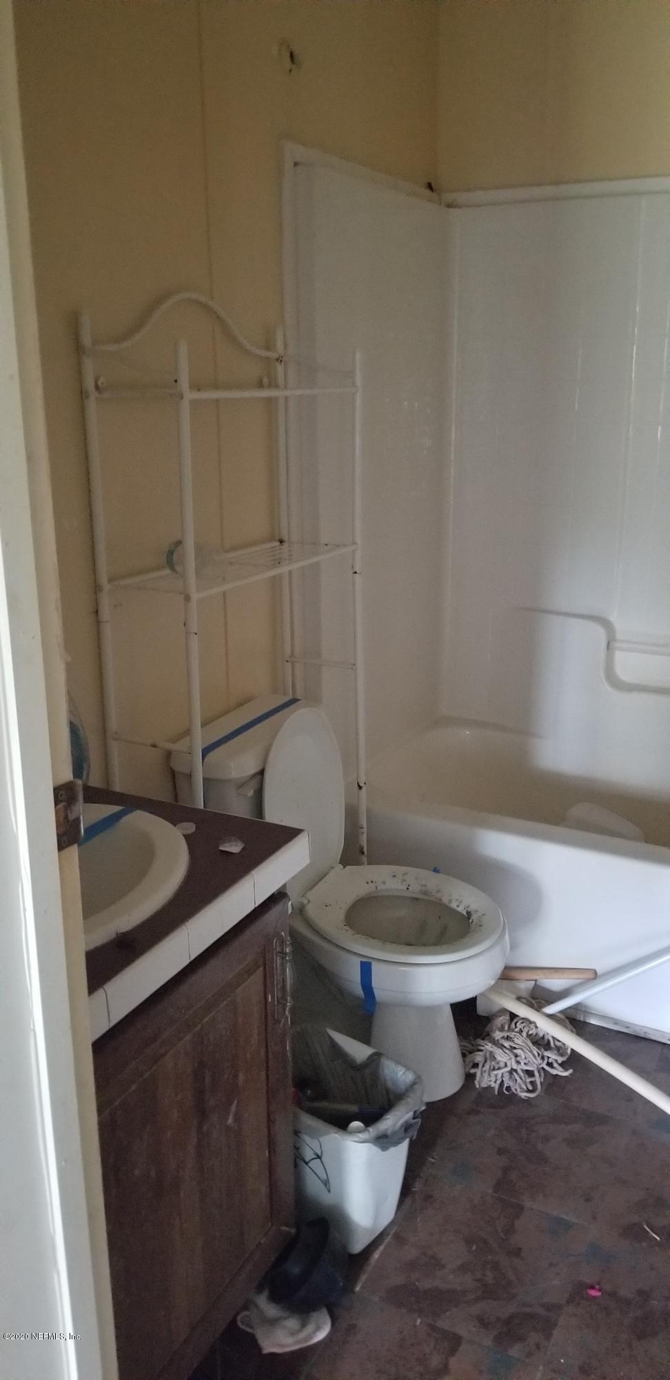 14003 Bradham Road Jacksonville, FL 32226 - Photo 25 of 30 a bathroom with a granite countertop sink and a toilet