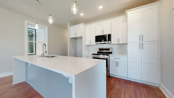 an empty room with wooden floor fireplace and windows