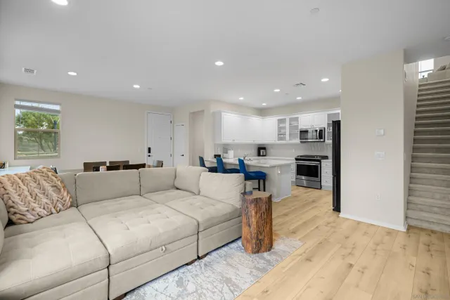 a living room with furniture and view of kitchen