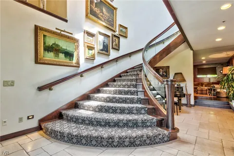 a view of staircase with lots of frames on wall and a large window