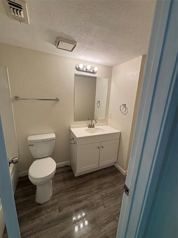 8127 Stonehurst Street, Unit 4 Dallas, TX 75217 - Photo 3 of 6 a bathroom with a toilet sink and a mirror