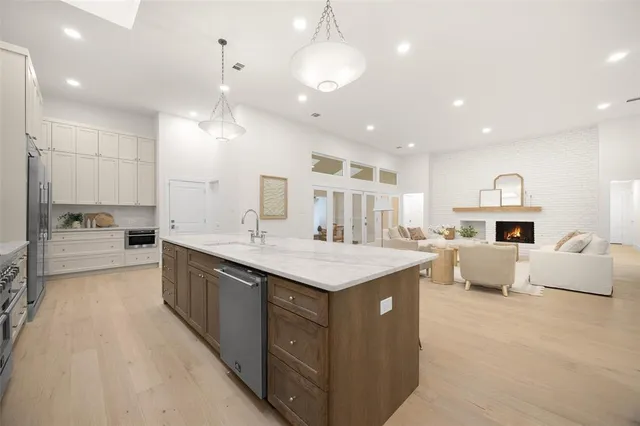 a large kitchen with kitchen island a sink a center island a stove and a cabinets