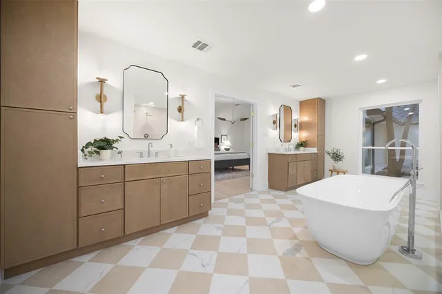a large bathroom with a sink a toilet a mirror and bathtub