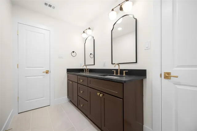 a bathroom with a double vanity sink and a mirror
