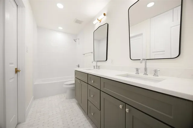 a bathroom with a double vanity sink double mirror and bathtub