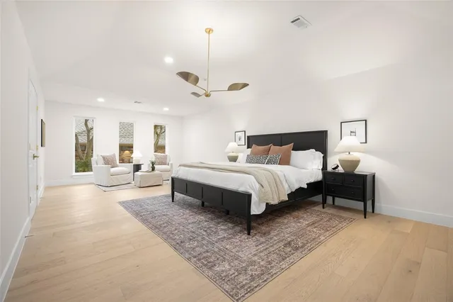 a spacious bedroom with a bed a table and chairs