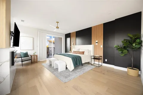 a bed room with a bed television and a large window