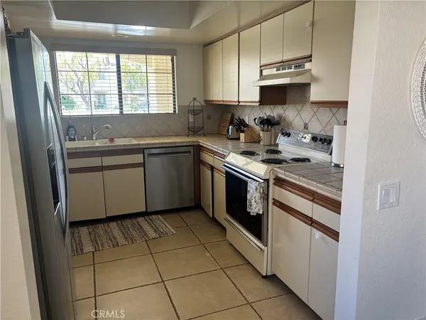 a kitchen with stainless steel appliances granite countertop a stove sink and cabinets