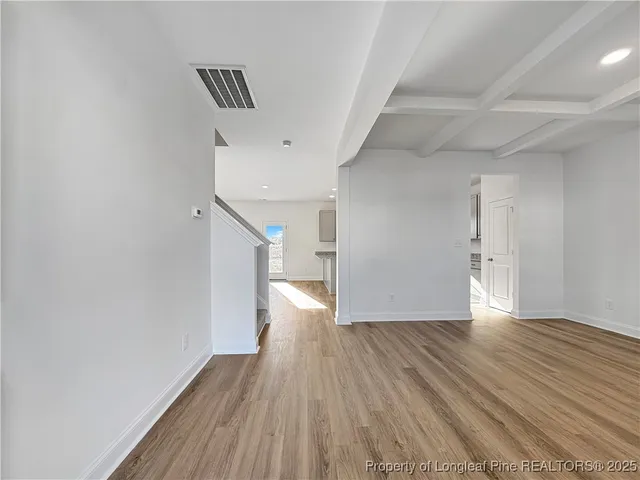 a view of a big room with wooden floor and windows