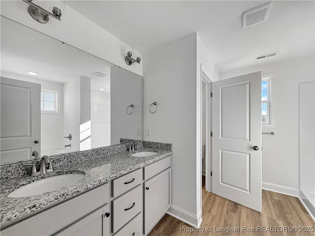a bathroom with a granite countertop sink mirror and