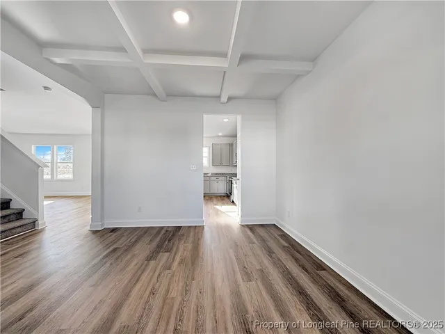 a view of empty room with wooden floor and window