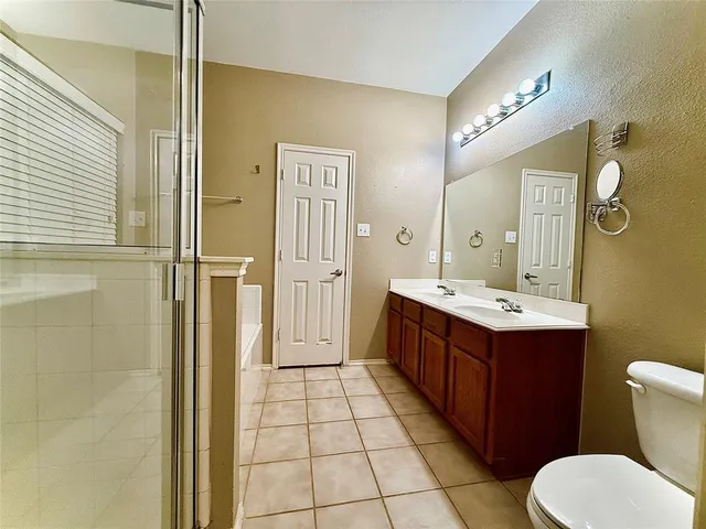 a spacious bathroom with a double vanity sink mirror and toilet