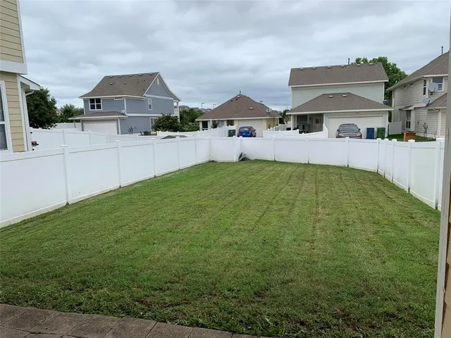 a front view of house with yard and trees in the background